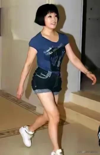 照片中的刘晓庆，穿的很清爽，迈开大步往前走，看起来英姿飒爽，给人一种积极向上的力