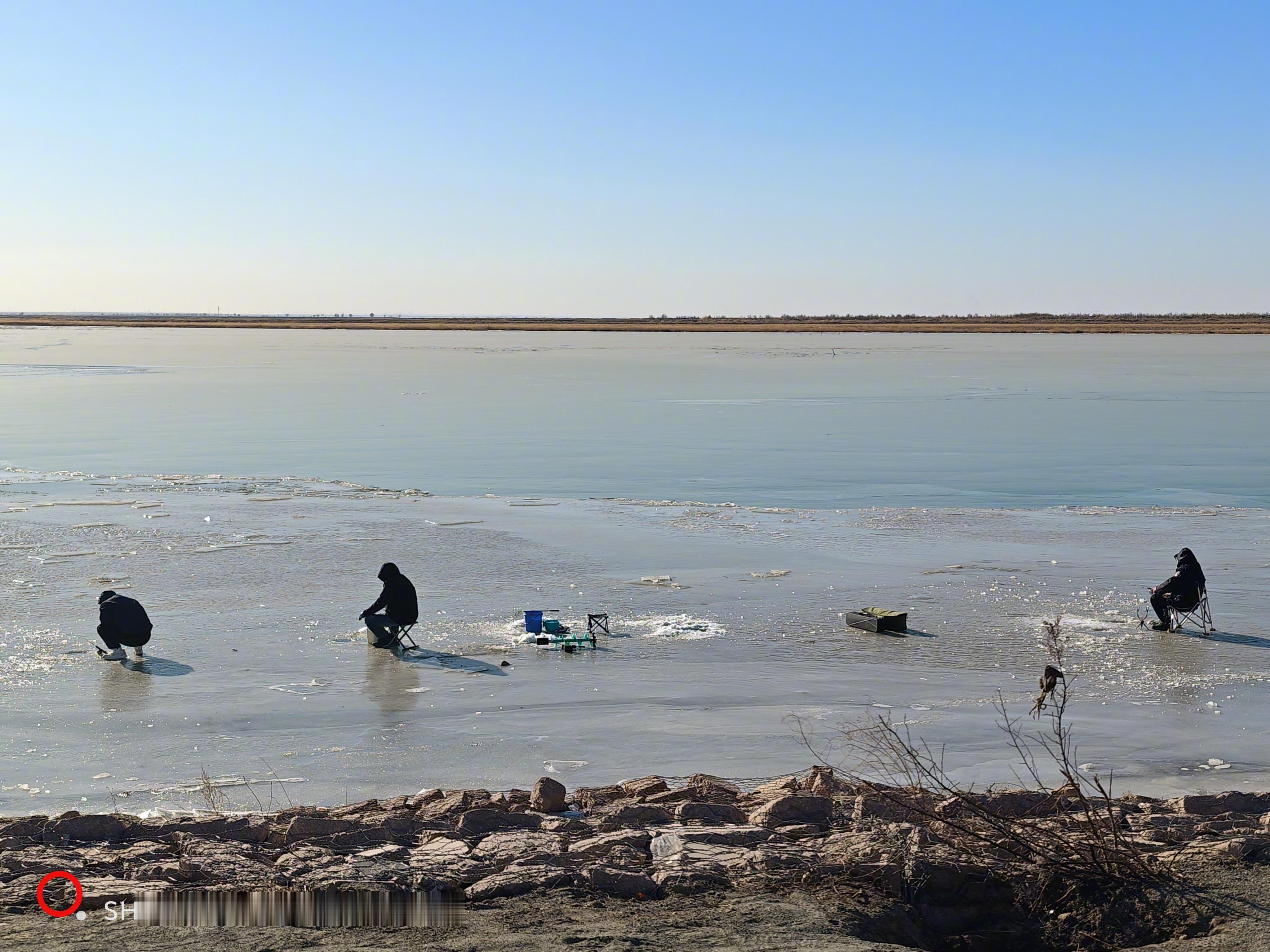 这是内蒙古段的黄河，平静的母亲河。人们已在破冰钓鱼。 