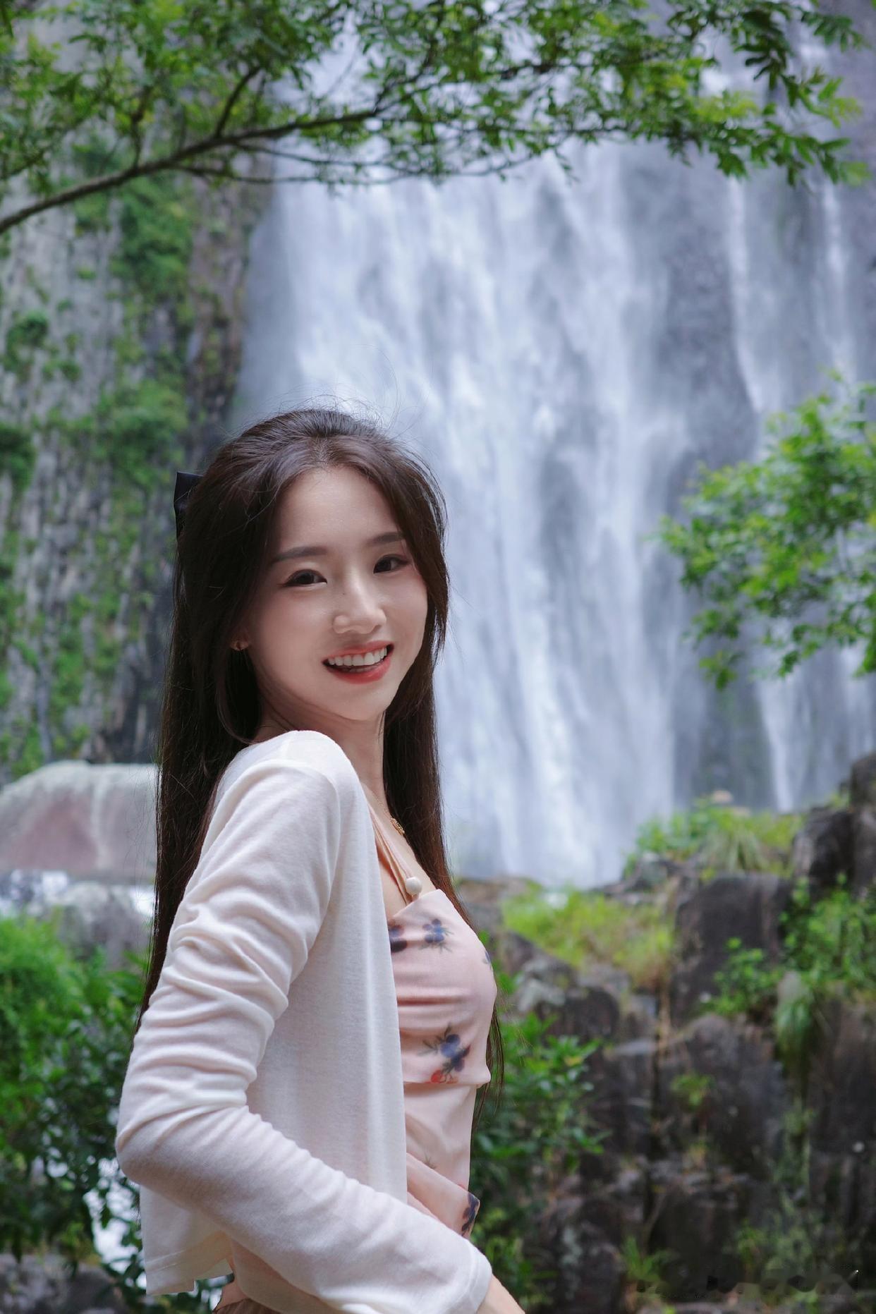少女漫步在瀑布旁，轻纱飘逸，宛如仙境。