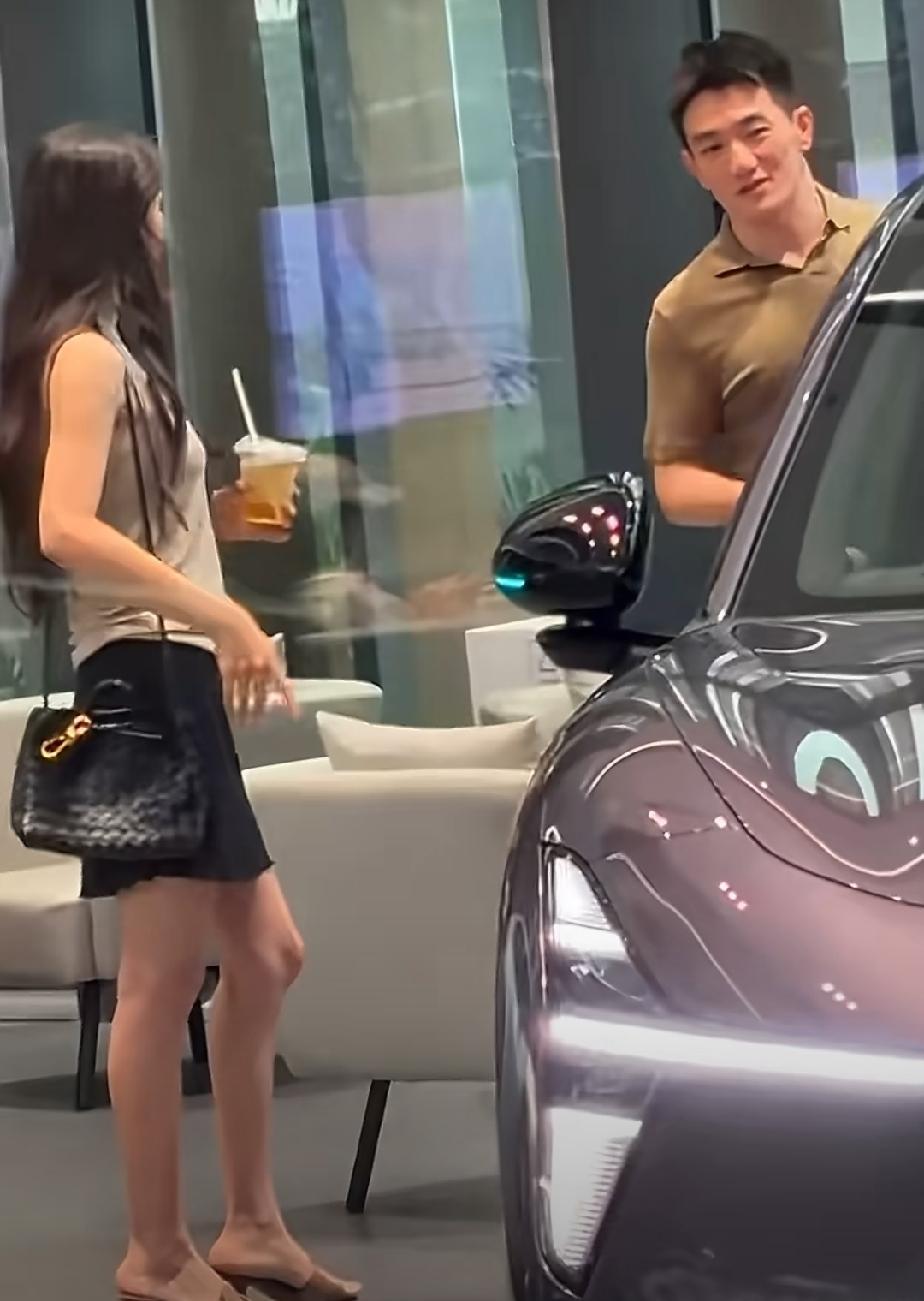 网友在小鹏科技园偶遇张馨予何捷夫妇在看车，何捷在看车外观后备箱，张馨予站在一旁陪