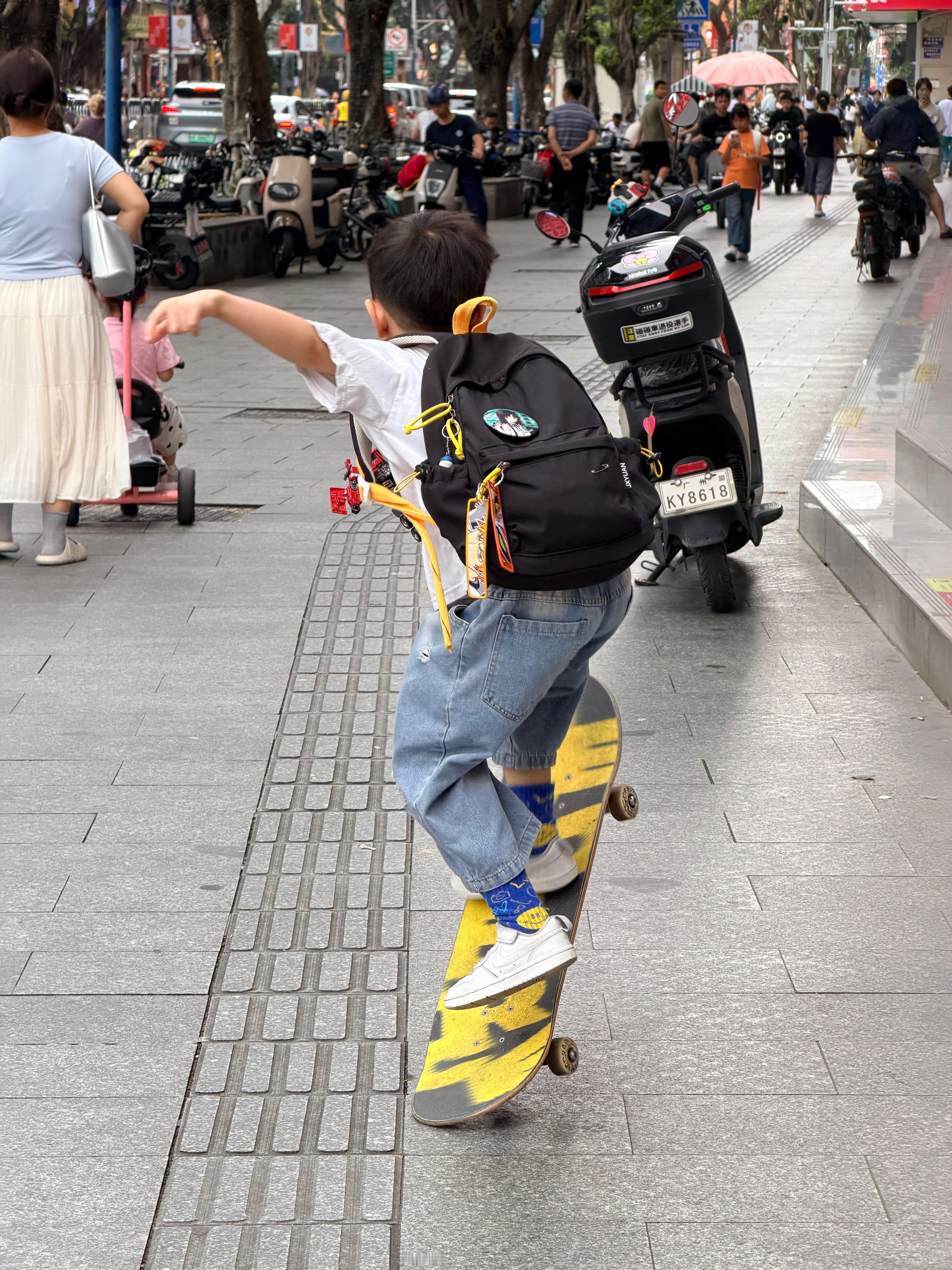 “今天不背书包🎒，衣服我给你拿吧？”“不行！我要背。背着书包🎒滑滑板比较帅一