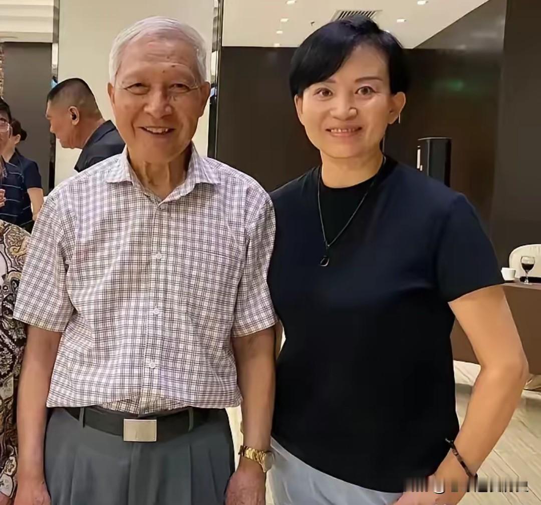 在这张合影中，满头银发的钱树根上将与战地女记者梁子并肩站在一起，脸上挂着温和的笑