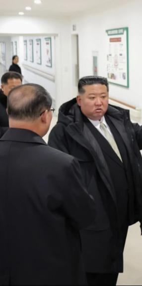 在龟城市医院竣工典礼后，玄姐站在医院走廊不远处的光影里，视线轻轻笼着前方，没靠近