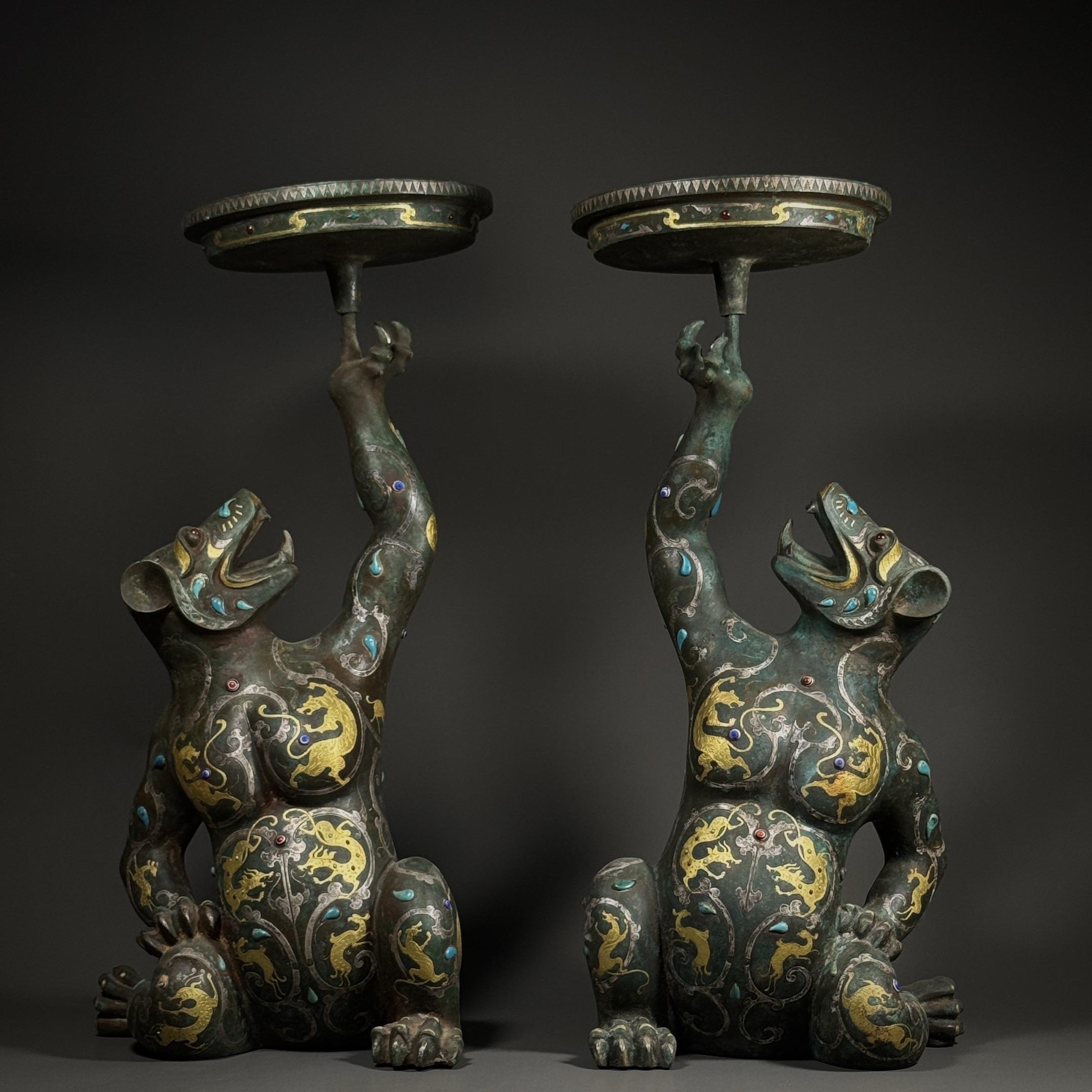 青铜灯太。战国错金银嵌宝熊形青铜灯台一对，熊躯蹲踞昂首，前爪擎灯盘欲触...
