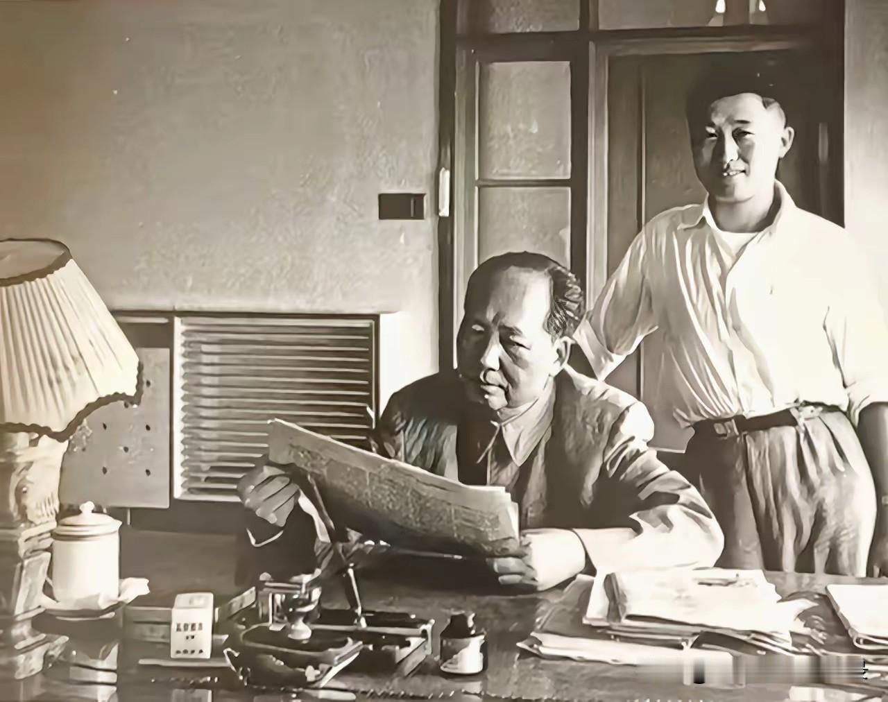 毛主席在湖北武汉东湖宾馆办公桌前阅读文件，身后是他的贴身卫士兼理发师周福明。[玫