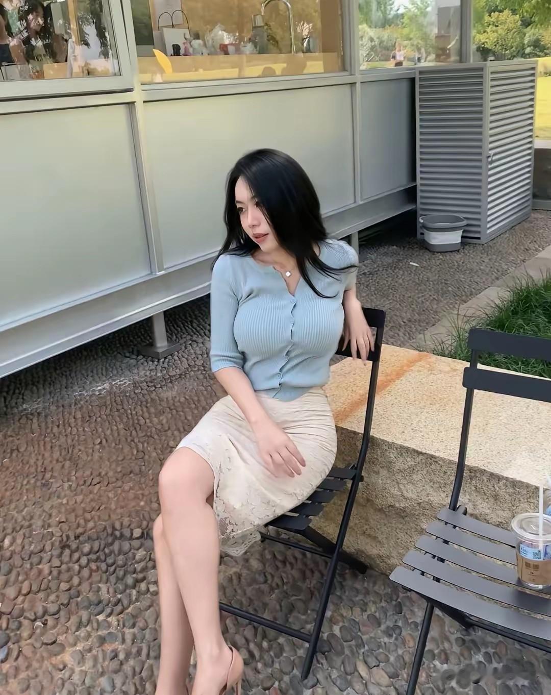 这位女士坐在户外享受咖啡。