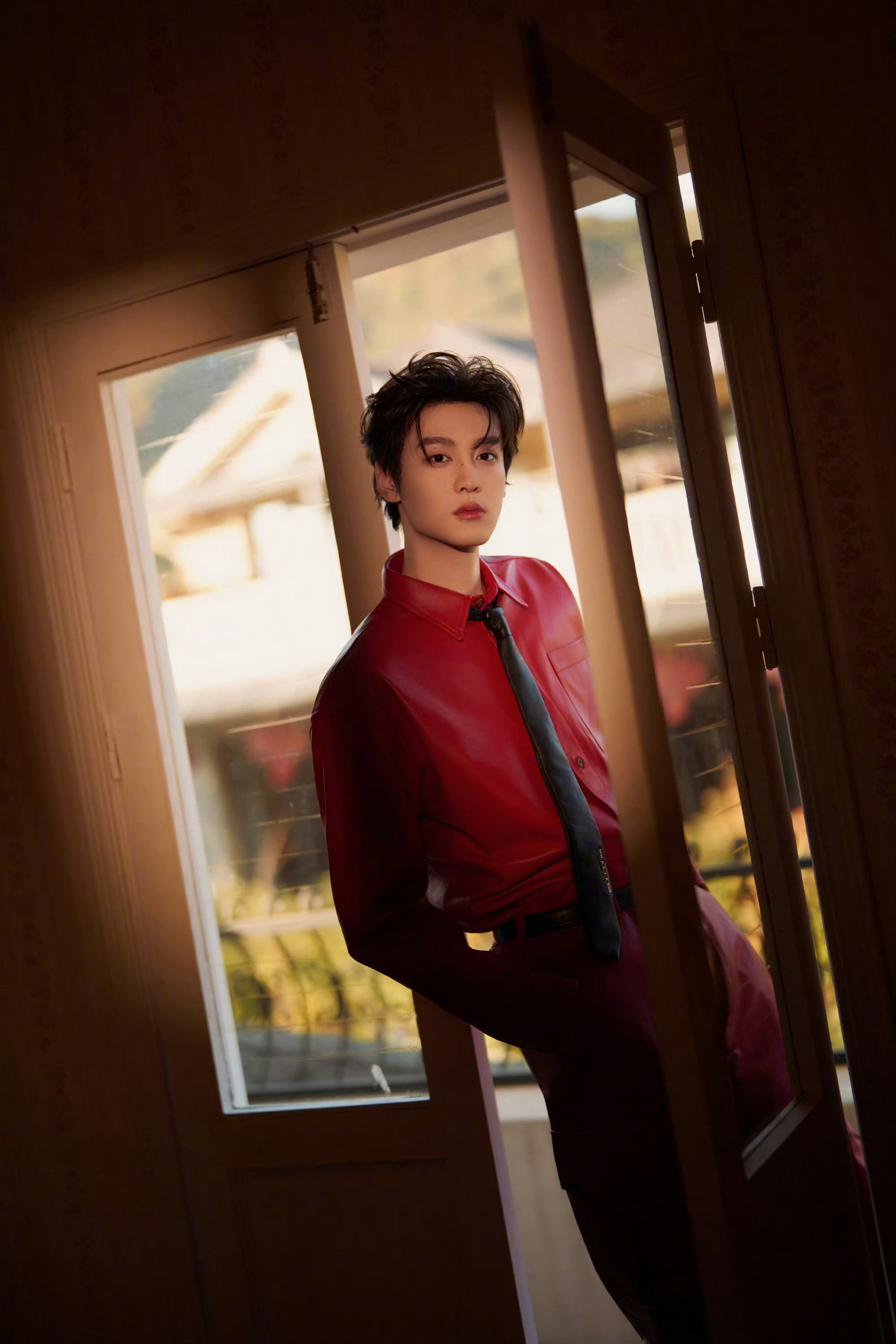田栩宁新春大片，身穿AMBUSH 25秋冬红色皮衣套装，搭配黑色领带，硬挺的版型