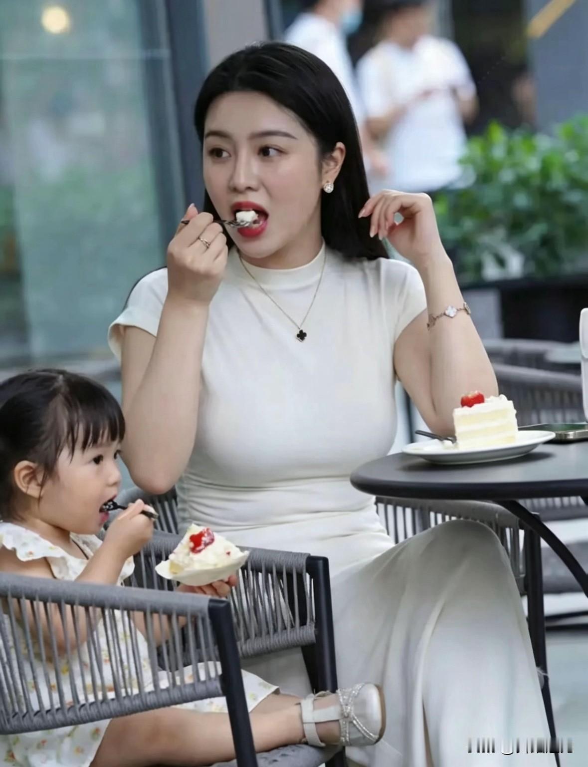 午后的风裹着蛋糕的奶香，漫过露天藤椅。一位年轻的母亲就那样松松散散地坐着，陪小丫