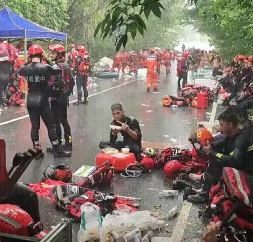 “泪目了”消防战士盘腿坐在地上吃饭，老天爷偏在这个时候又开始肆虐，雨又哗啦啦地下