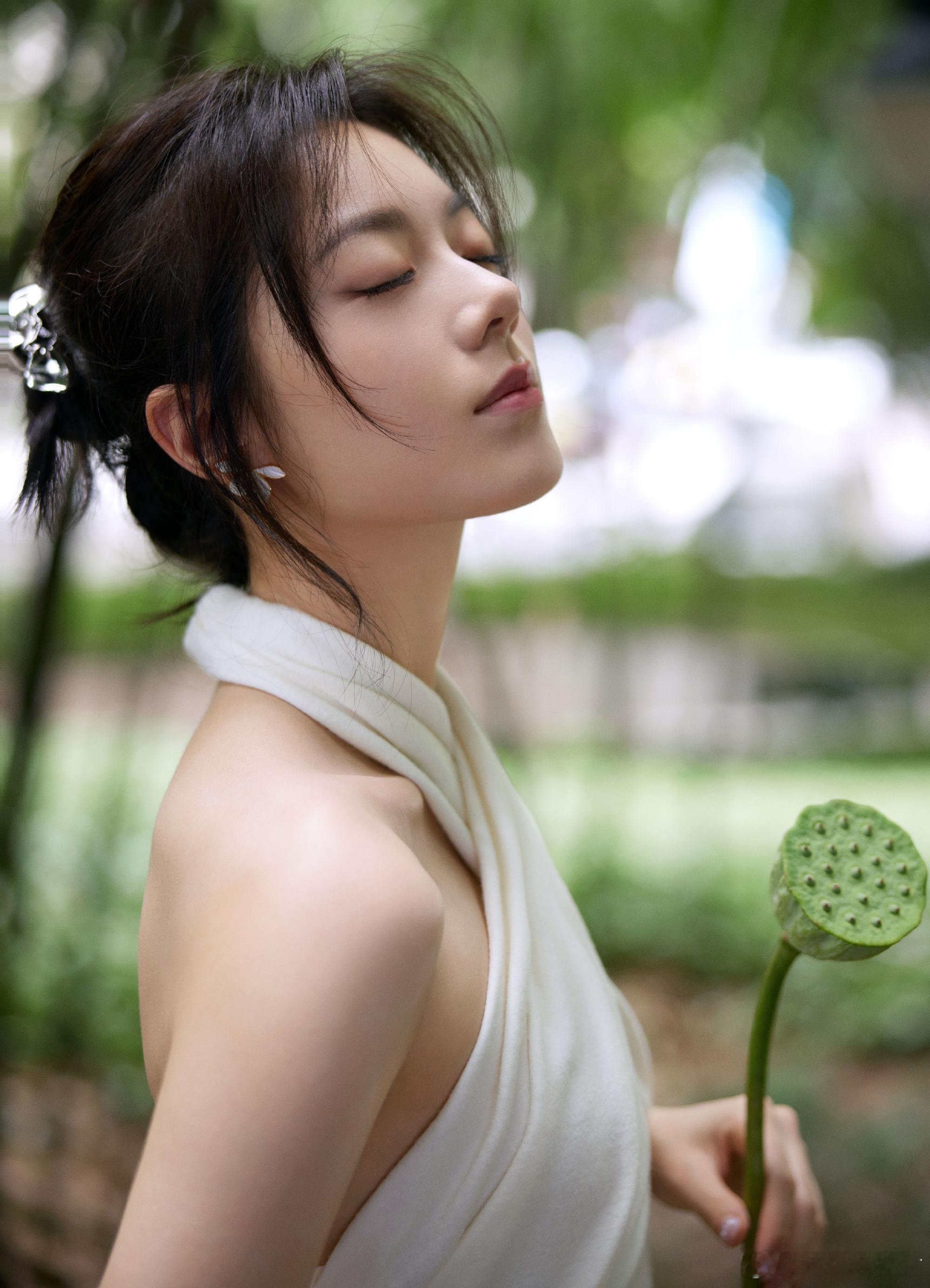 近日，赵今麦工作室发布一组写真照。赵今麦身穿白色挂脖短裙，大秀美背。竹林山间，手