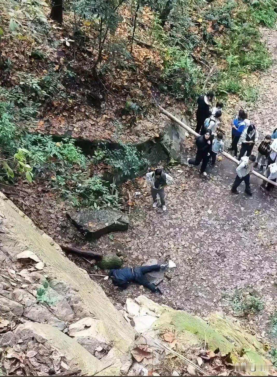 中年男子皮鞋西裤学年轻人爬南山大裂谷，不慎摔下石崖疑似骨折。事发12月27日左右