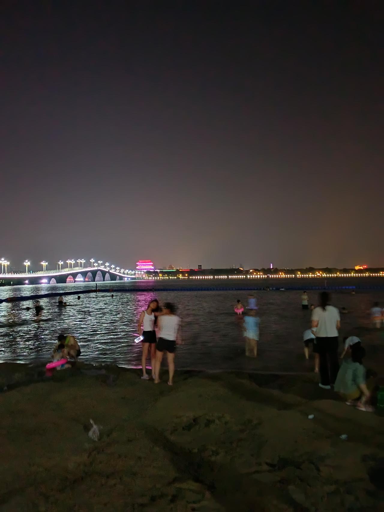沙滩上撞见聊城的夜
暮色沉落时，东昌湖先接住了第一缕晚风。西关桥的霓虹沿着桥身铺