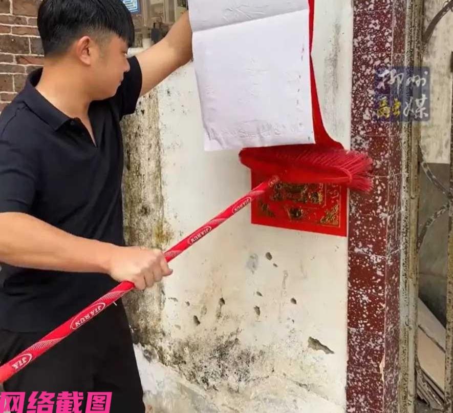 广东有小伙在家里贴春联，只是他用的方式有点特别，因为他用了家里的扫帚直接上手推贴