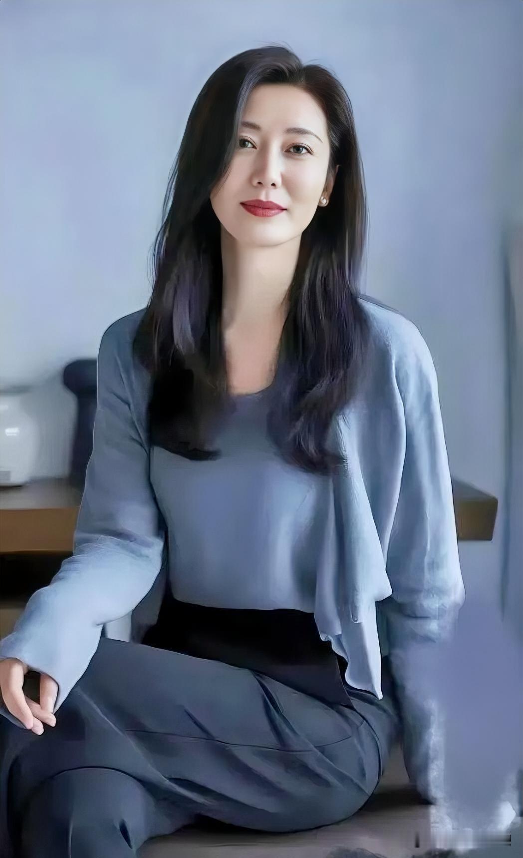 墨发如云静倚窗，

蓝衫素雅衬端庄。

明眸浅笑含春意，

温婉从容气自芳。
