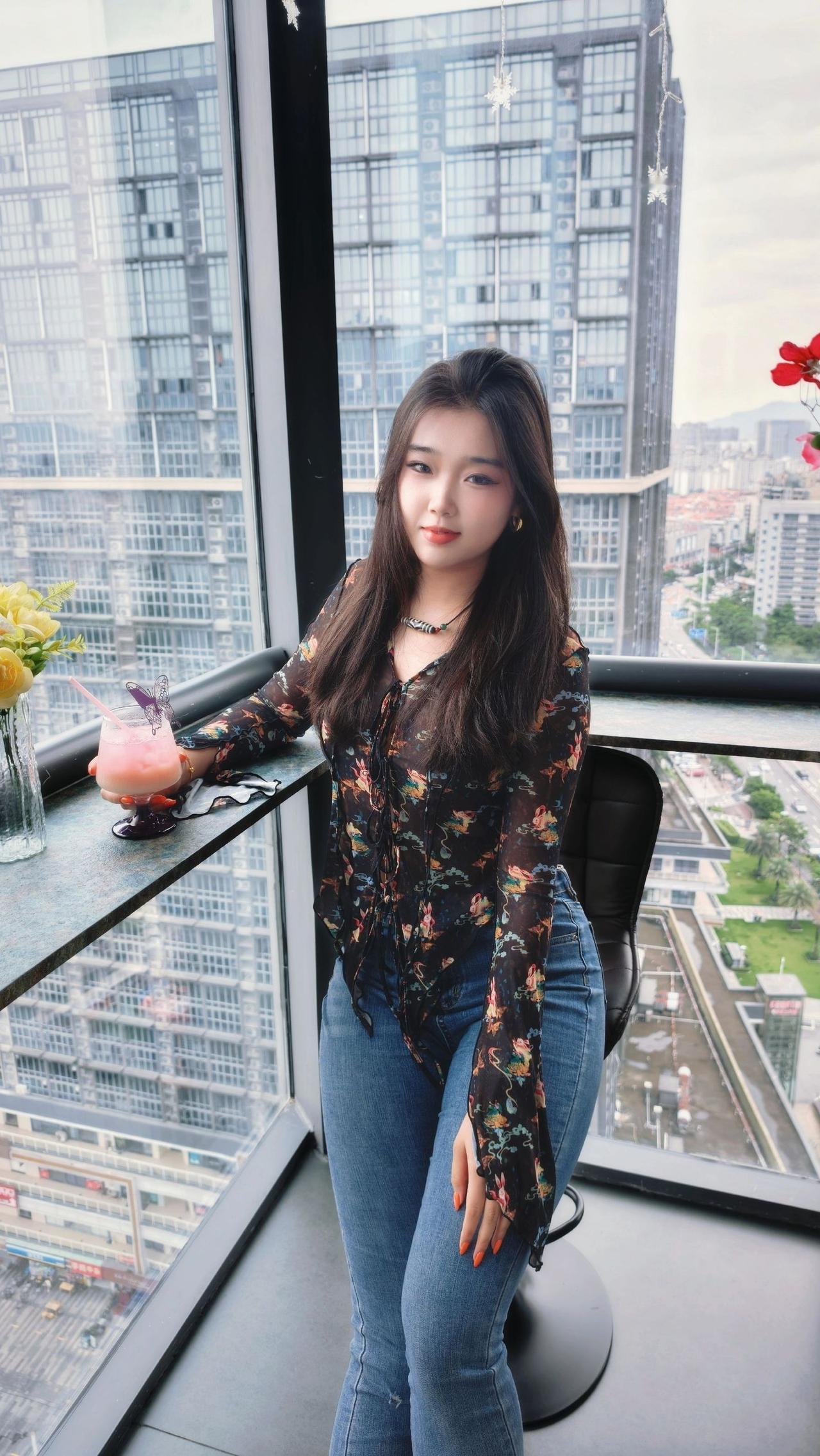 女孩坐在窗边，享受城市美景。