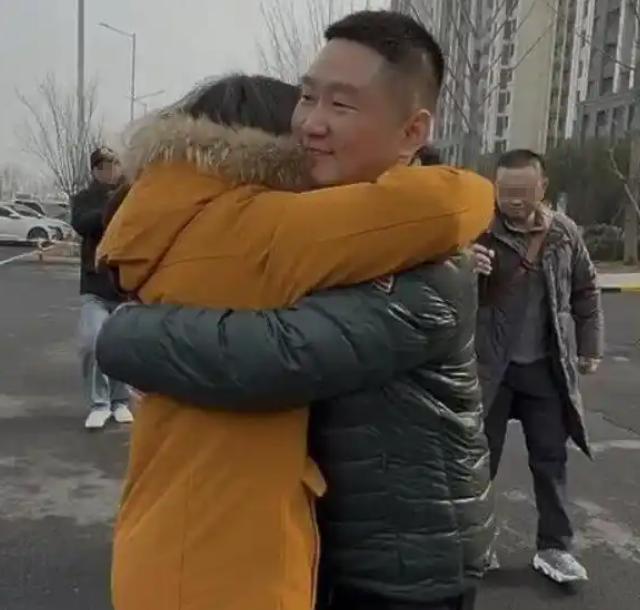 新乡东站出站口，来自北京的一个女人扔下行李箱，冲过去抱住一个男人，哭得浑身发抖。