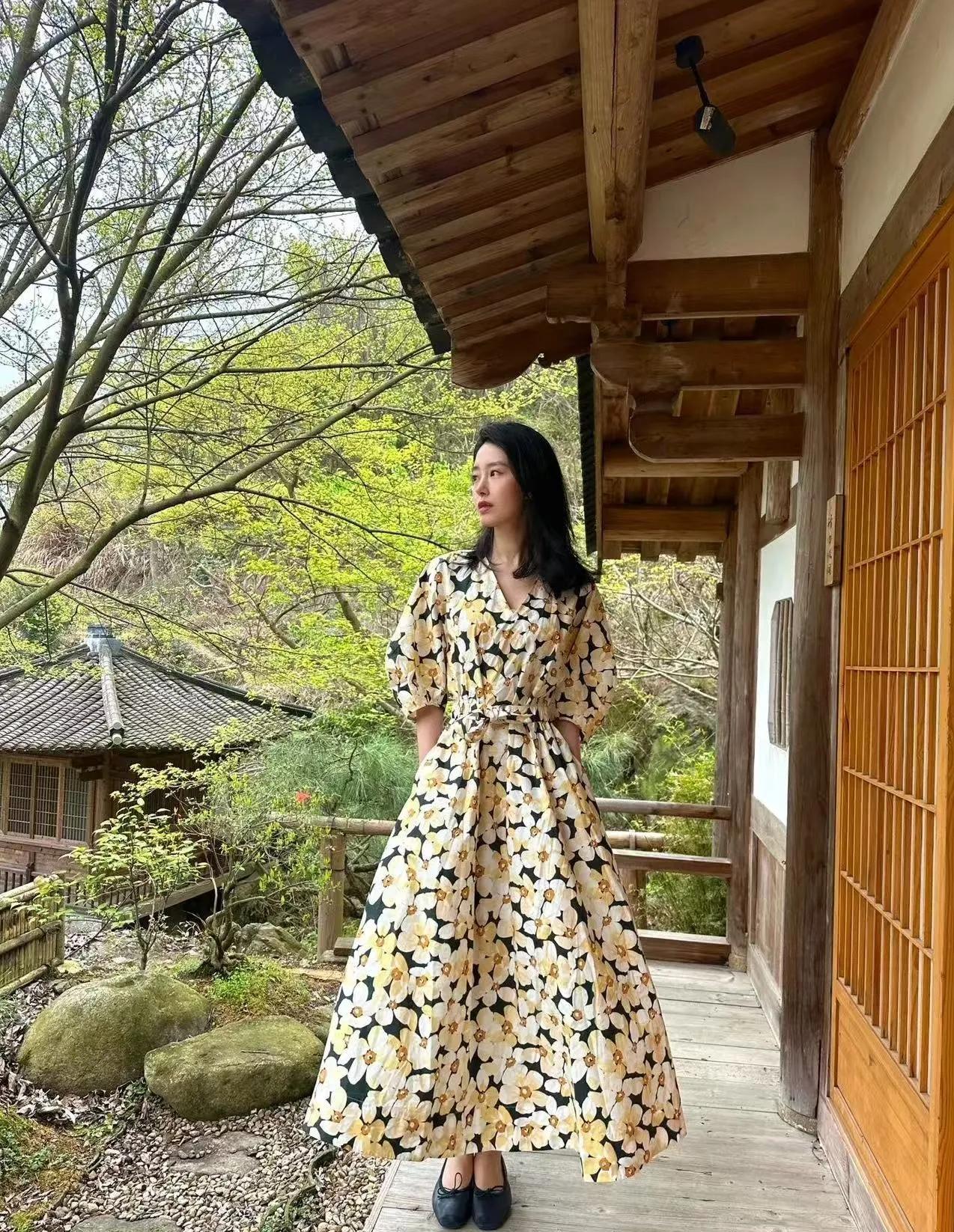 杨采钰碎花裙穿搭封神！
黑底黄白花V领长裙，自带法式温柔滤镜
搭配新中式木屋景致