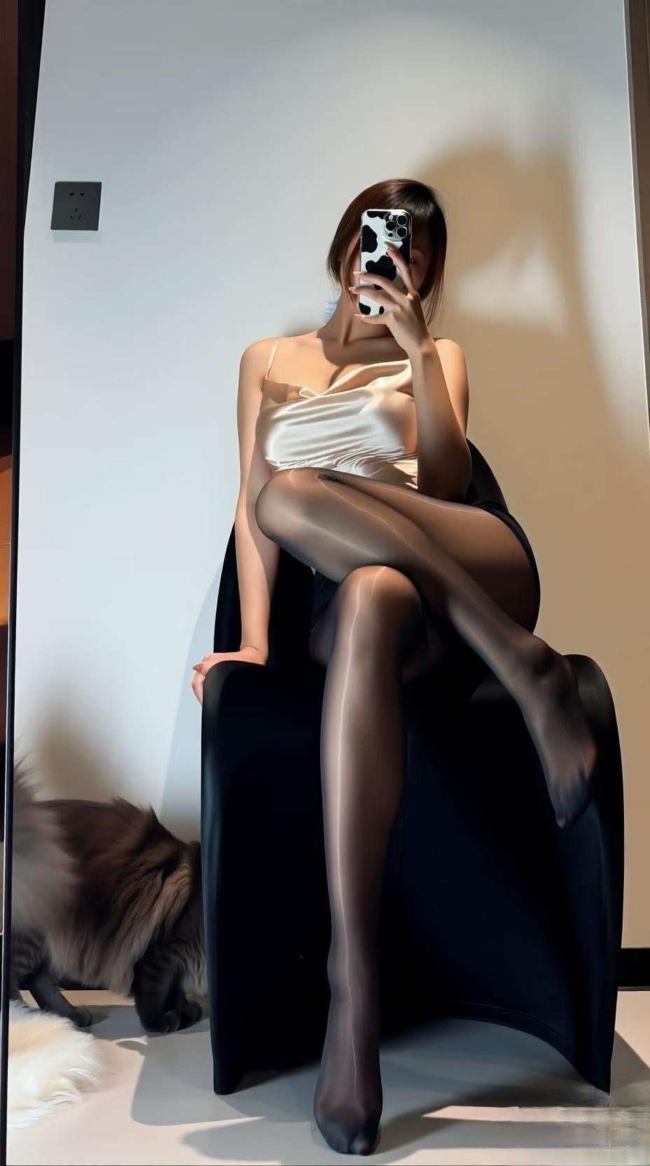 手机举到脸前时，丝滑的香槟色吊带蹭了下锁骨。黑丝袜在腿上泛着细闪的光，和旁边那团