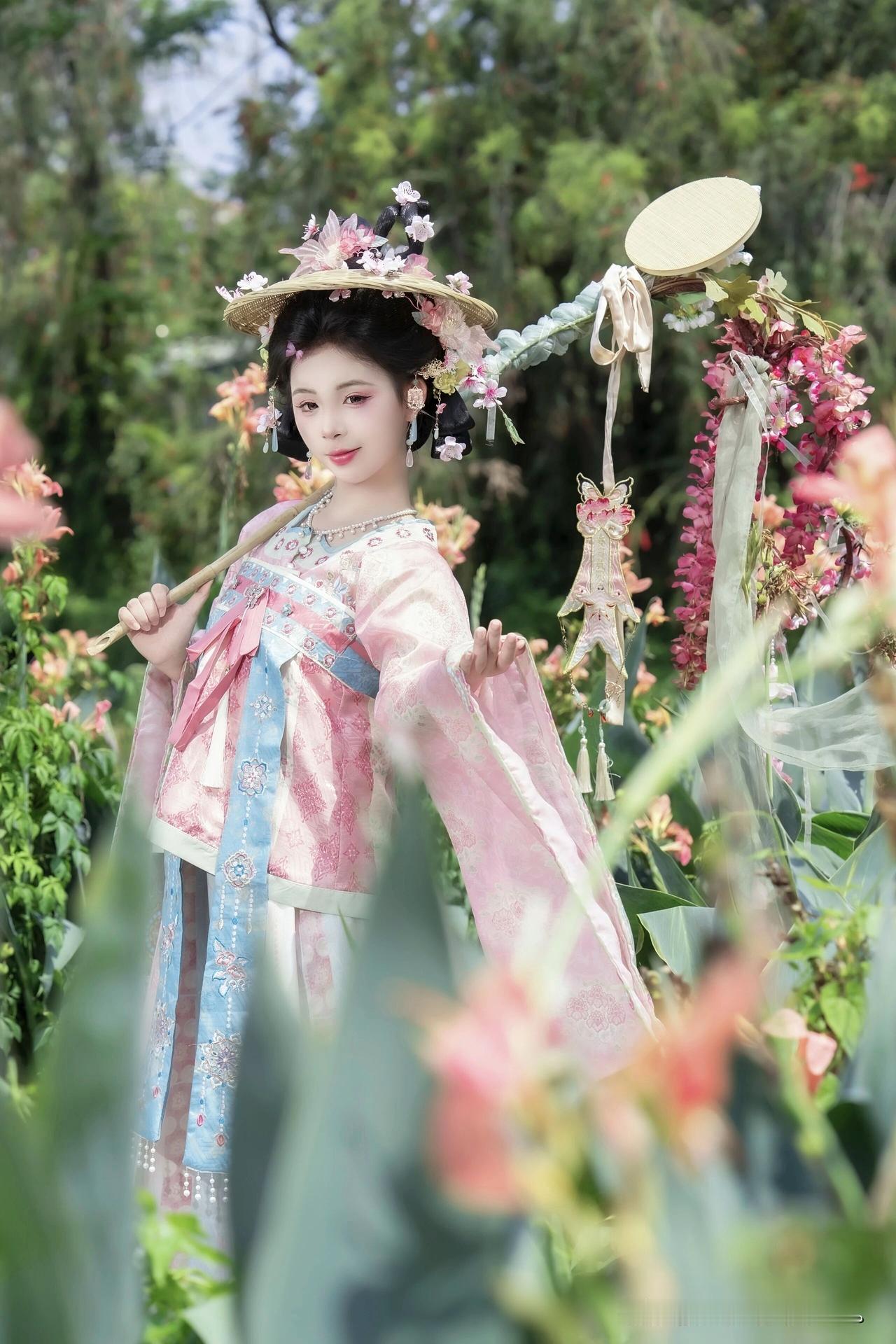 像是从山水画里走出的仙子。
身畔是碧波荡漾的江水，
身后是连绵起伏的青山。
不需