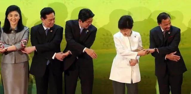 一张合影，三张熟悉的面孔，安倍晋三，朴槿惠，英拉。他们手拉手笑得很开心，英拉美得