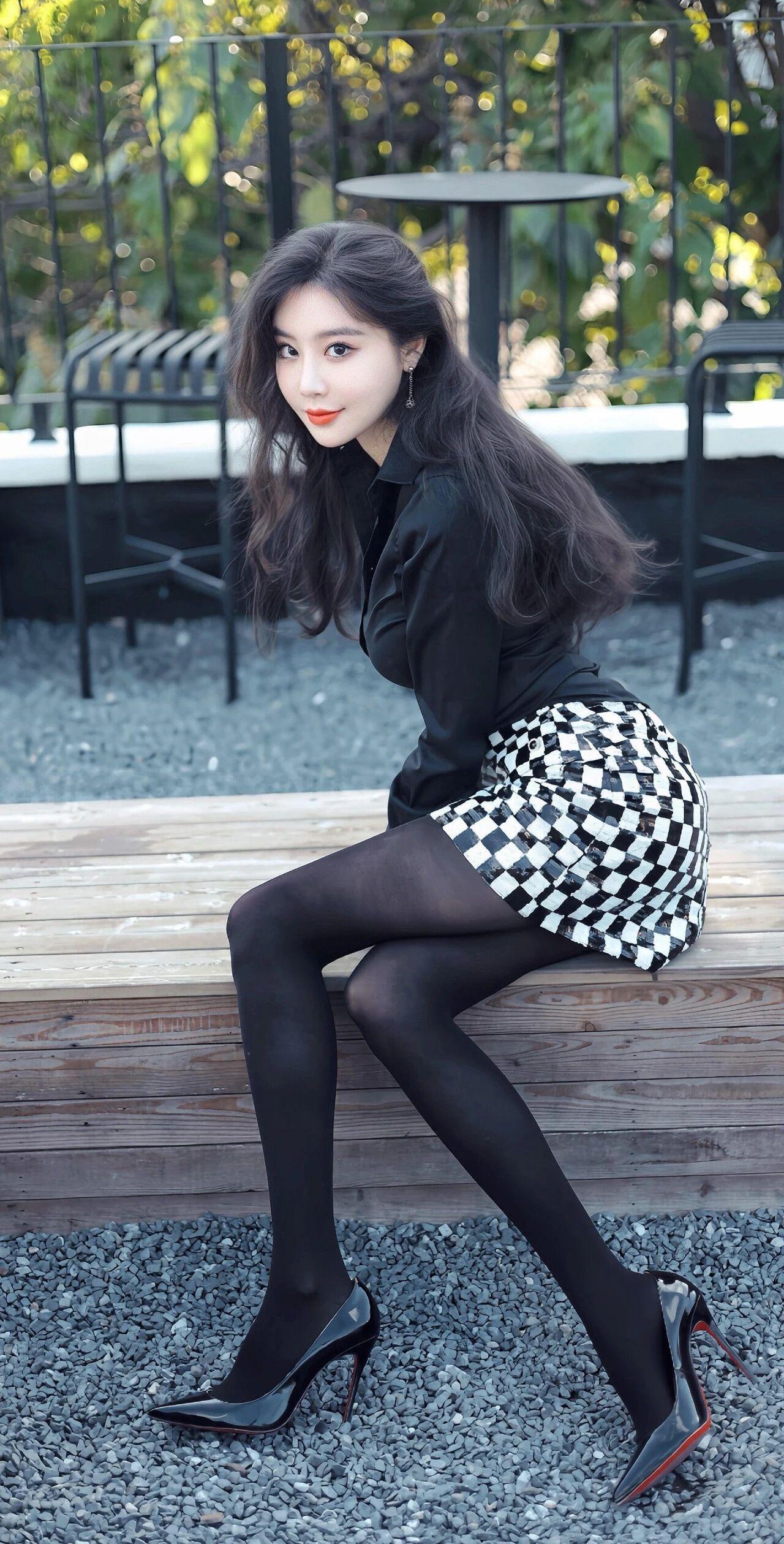 《午后时光的剪影》
黑色丝绒上衣像一片温柔的夜色，裹住她优雅的肩颈线条。黑白格纹