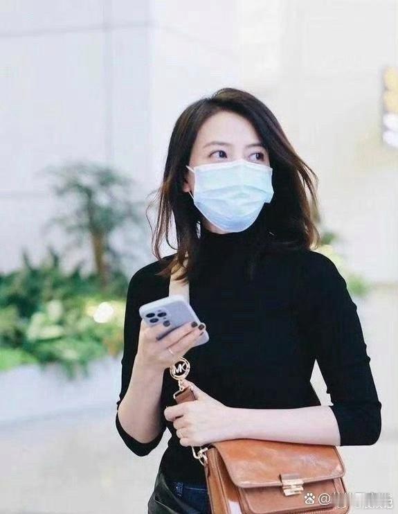 高圆圆又一次走在了时尚的前沿，外套系于腰间，与复古风格的喇叭裤相得益彰，勾勒出纤