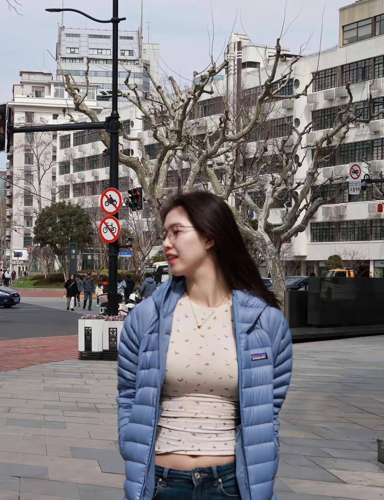 初春，天气咋寒还暖，羽绒服都穿上，配上牛仔裤，掩饰不住的好身材。眼镜增添了很多知