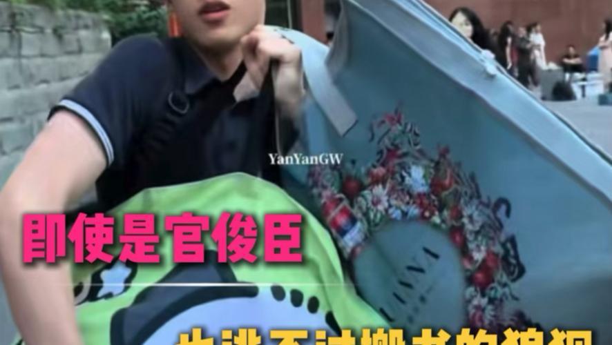 官俊臣搬运成堆书本时场面十分狼狈，怀里摞得高高的书籍不断晃动，双手吃力地托着，步