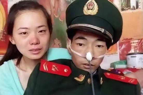 照片上的这个人身穿军装，骨瘦如柴，他此刻强打起精神，与妻子一起拍下了人生中最后的