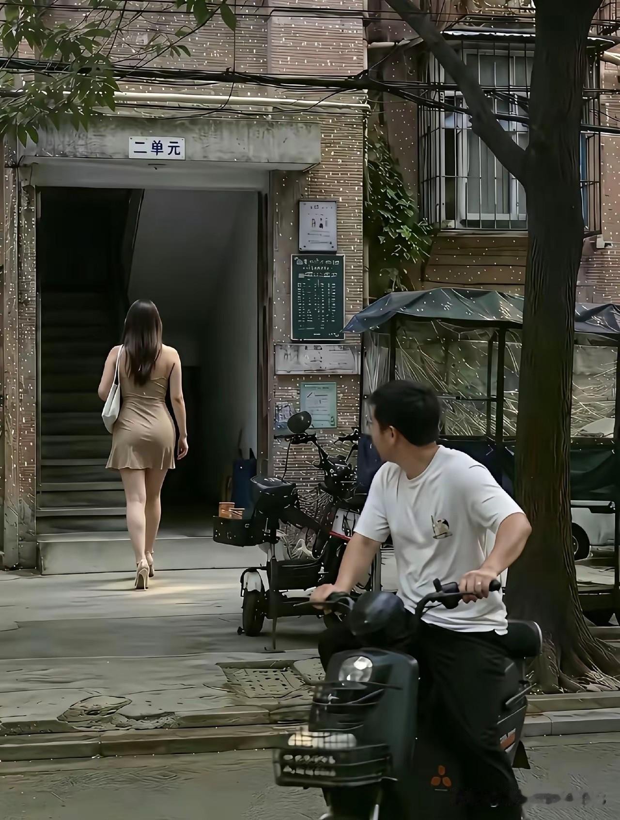 老小区寻常的一幕，藏着最真实的人间百态。

一位女士步履从容走向单元楼，骑电动车