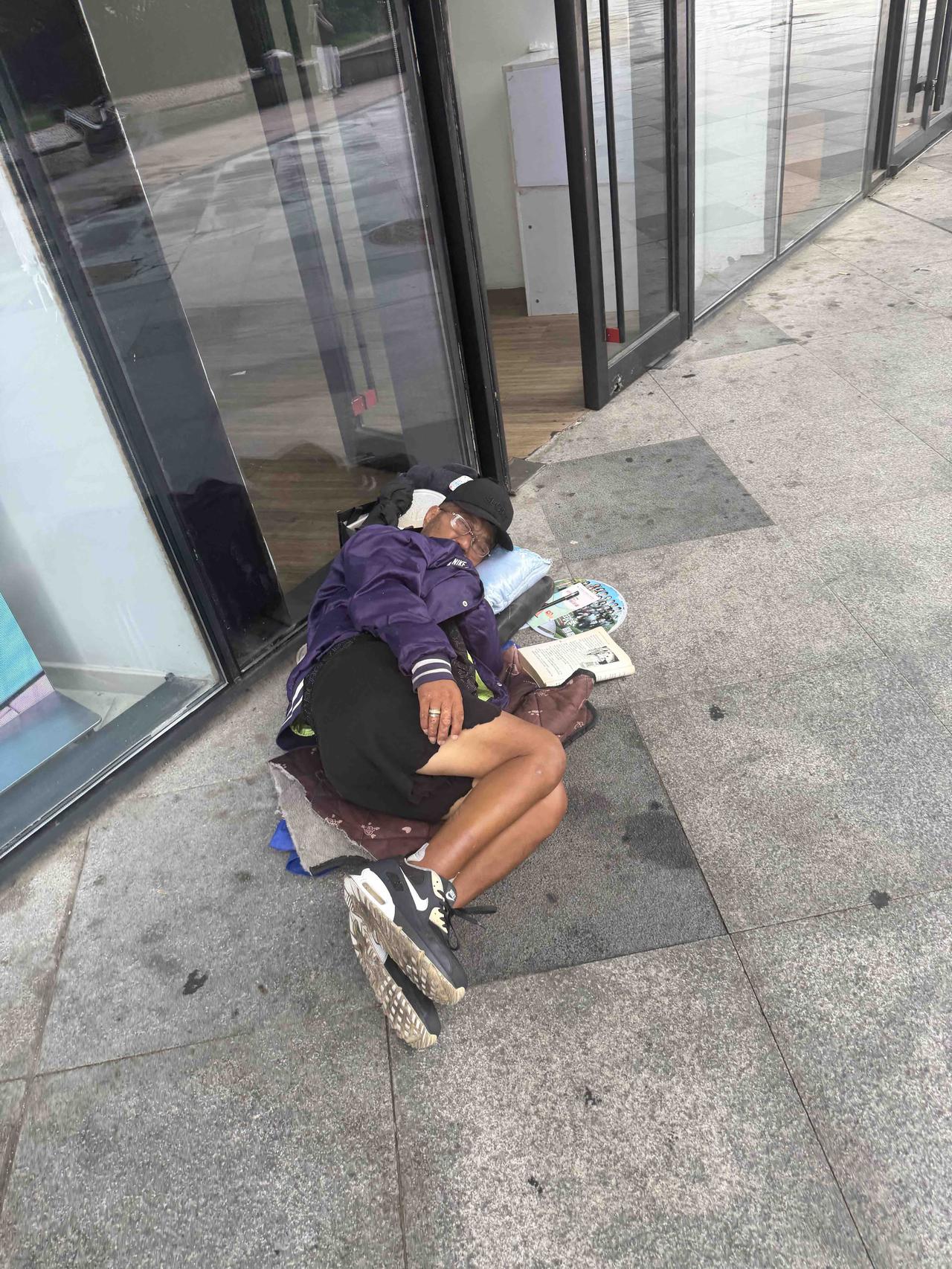 街头角落的“临时卧室”，大叔睡得真香！书都摊开在旁，看来是读书读累了呀。地铁口睡
