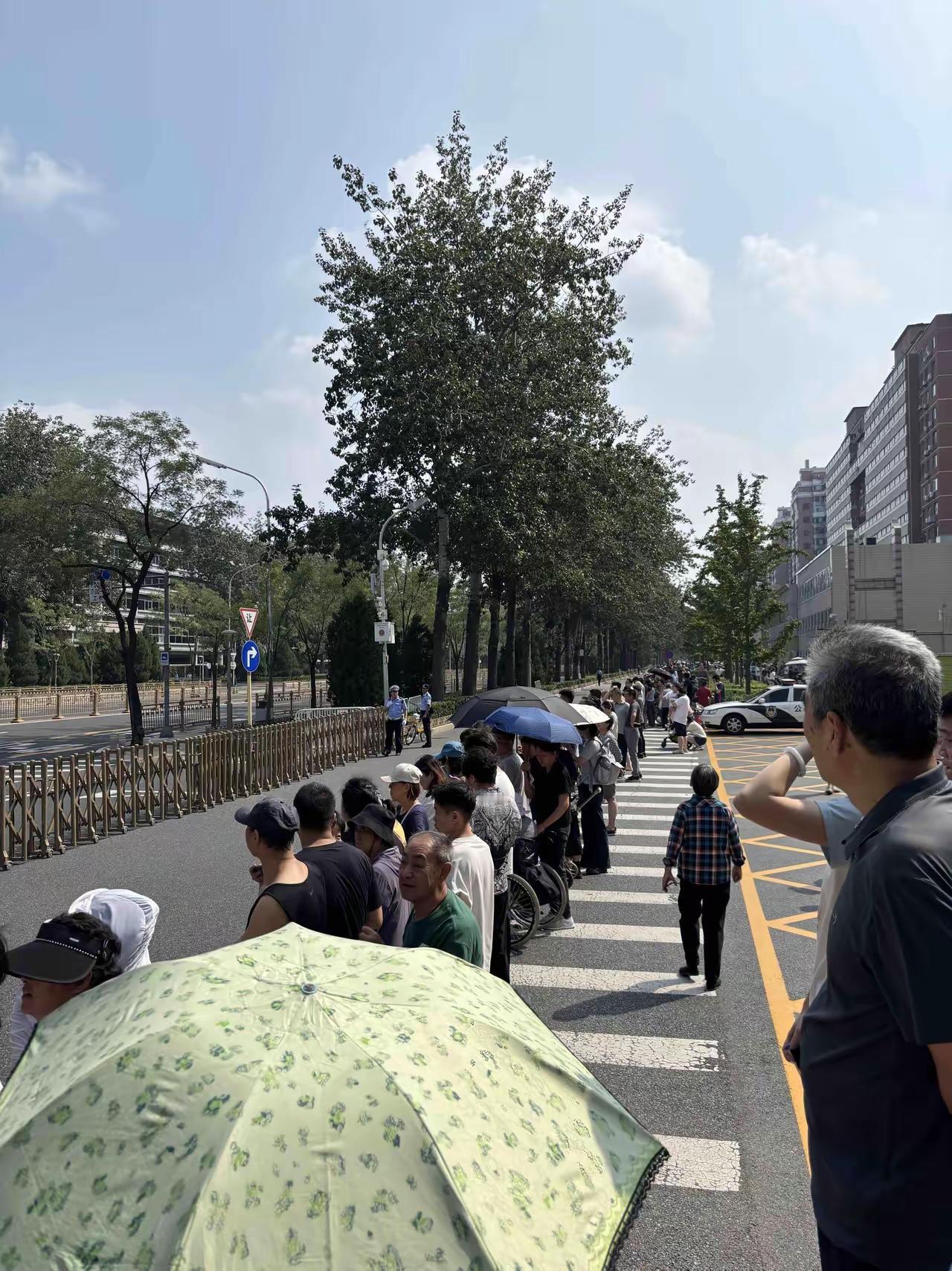 北京市民排成长龙，情绪高涨，热烈欢迎受阅部队载誉归来。