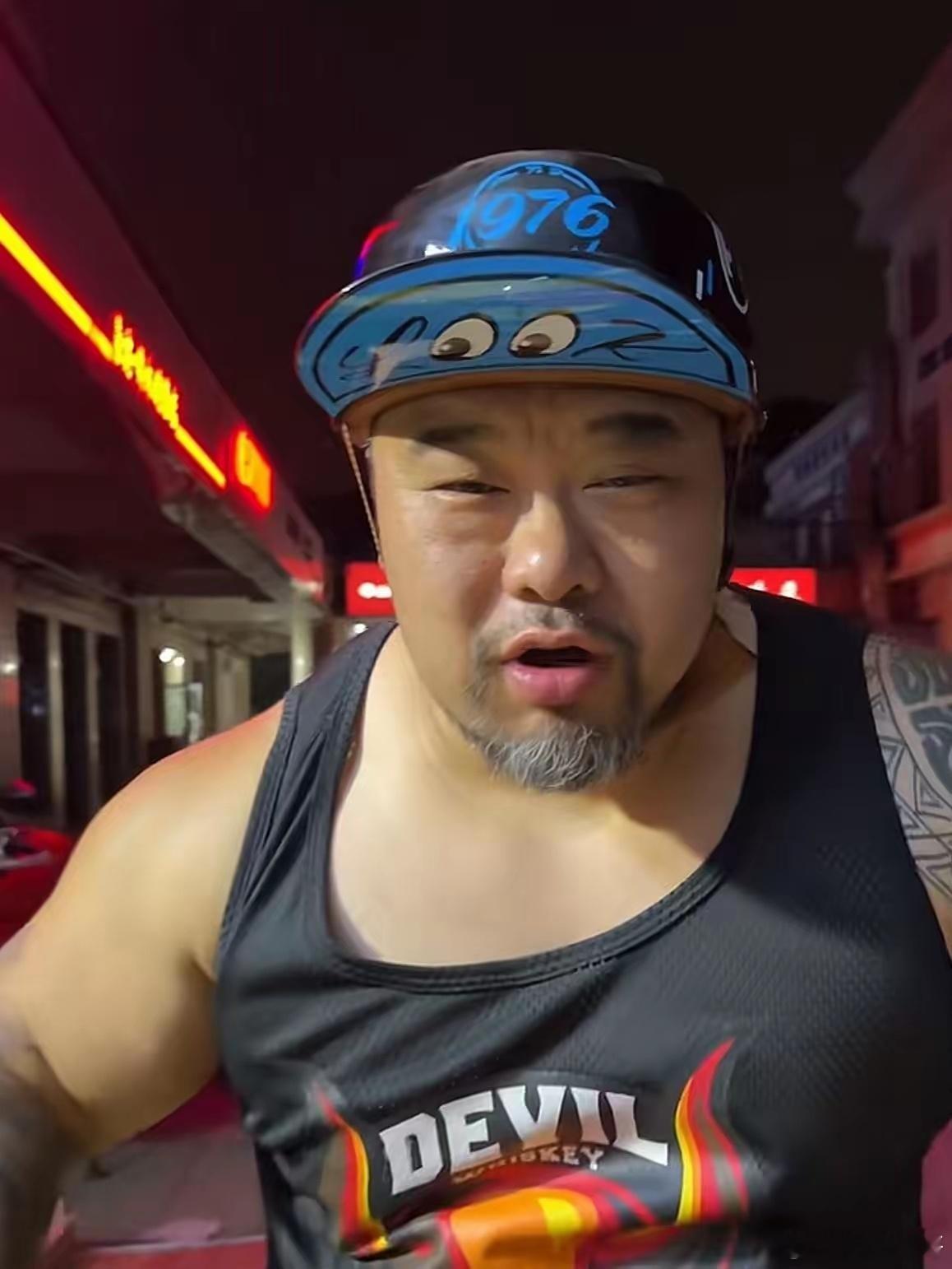 一个两百多斤的退役大力士，戴着粉色泳帽泡在充气泳池里抱玩具，旁边停着哈雷——你说
