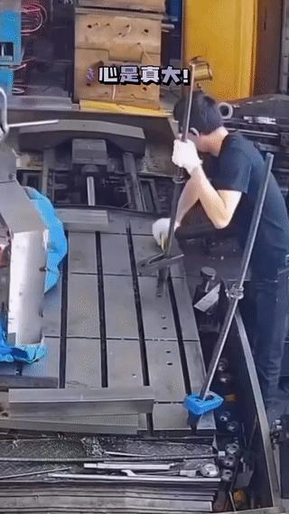一名工人在干活的时候突然被上方悬挂的一块金属工件砸中手指！
虽然他已经反应够快了