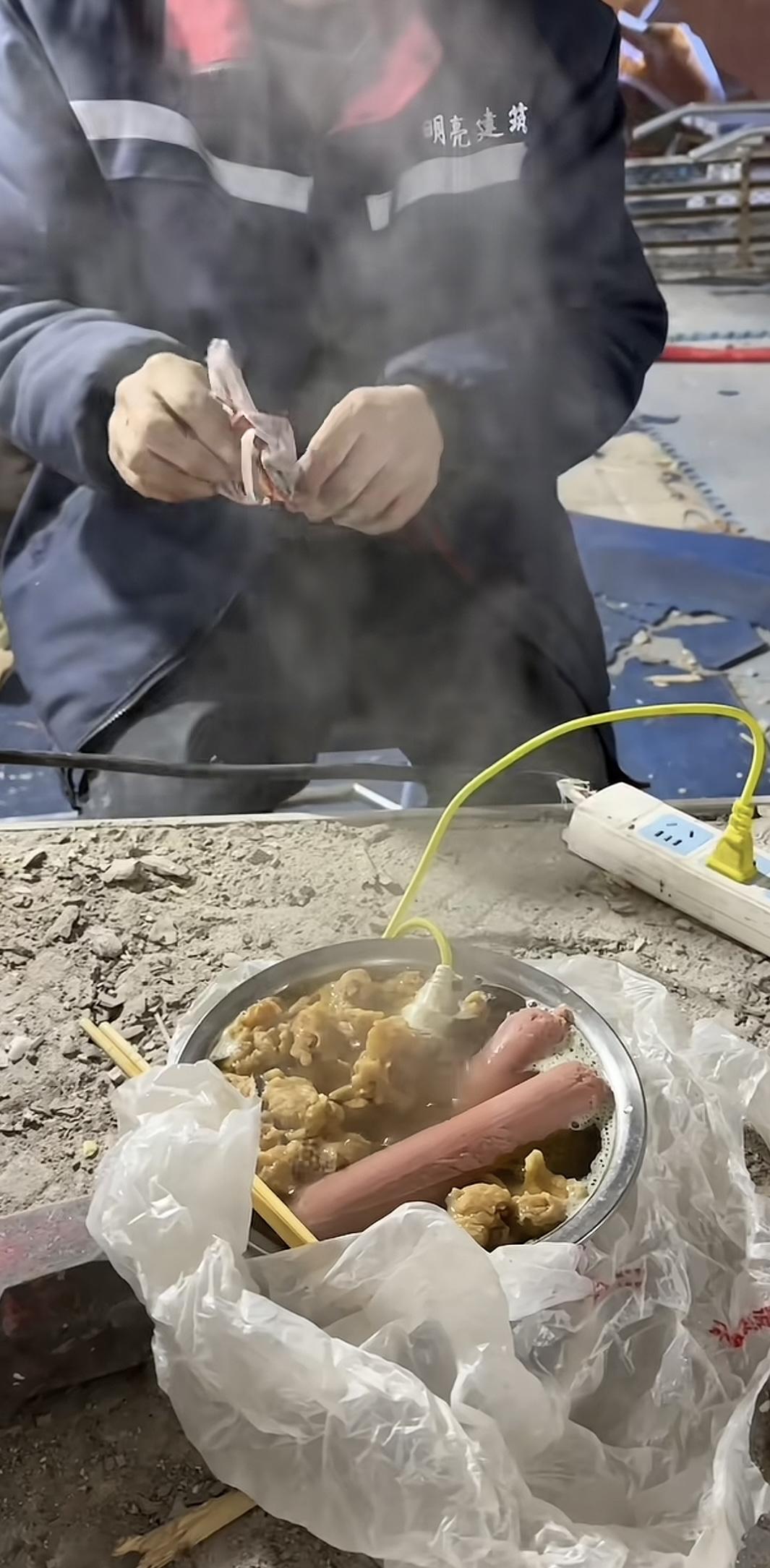 实在没有想到2026年了，还有这么节省的工人。
我们可以看到这位工人拿了一个吃饭