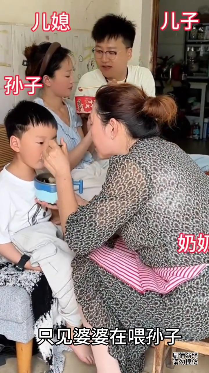 中午吃饭时间到了，只见婆婆在喂孙子，谁知旁边儿子在喂媳妇，这举动让婆婆一脸无奈。