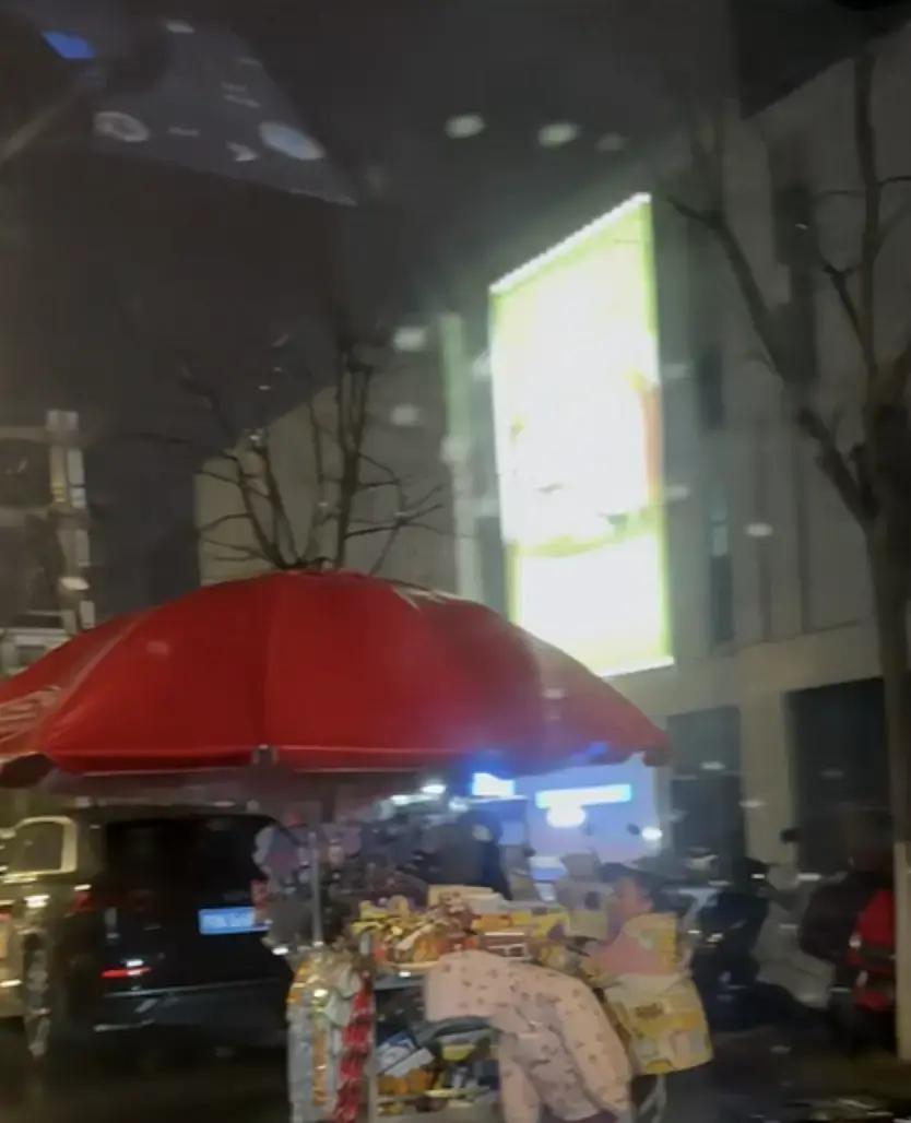 跨年夜安徽六安雨雪路滑，7岁小女孩和表妹帮妈妈推摆摊车回家，后车司机静静跟着十几