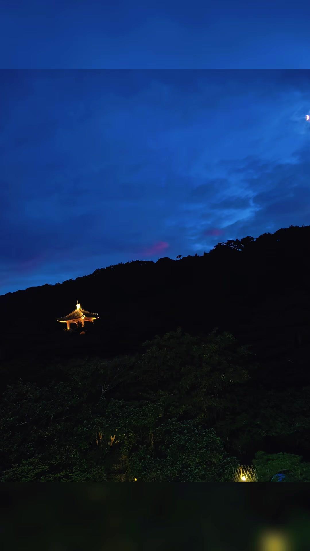 走在巷口抬头撞见整片漫开的蓝调天
远处黛青的山影静静铺在视线尽头
风裹着凉意在脸