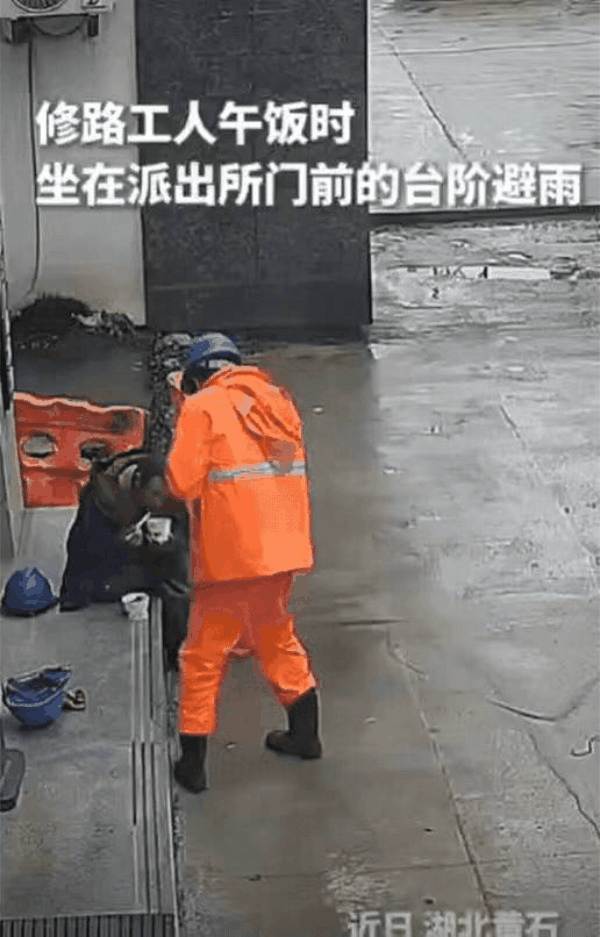 这民警火到人民日报了！湖北一群修路工人午饭时，为了避雨，来到派出所门前台阶坐下，