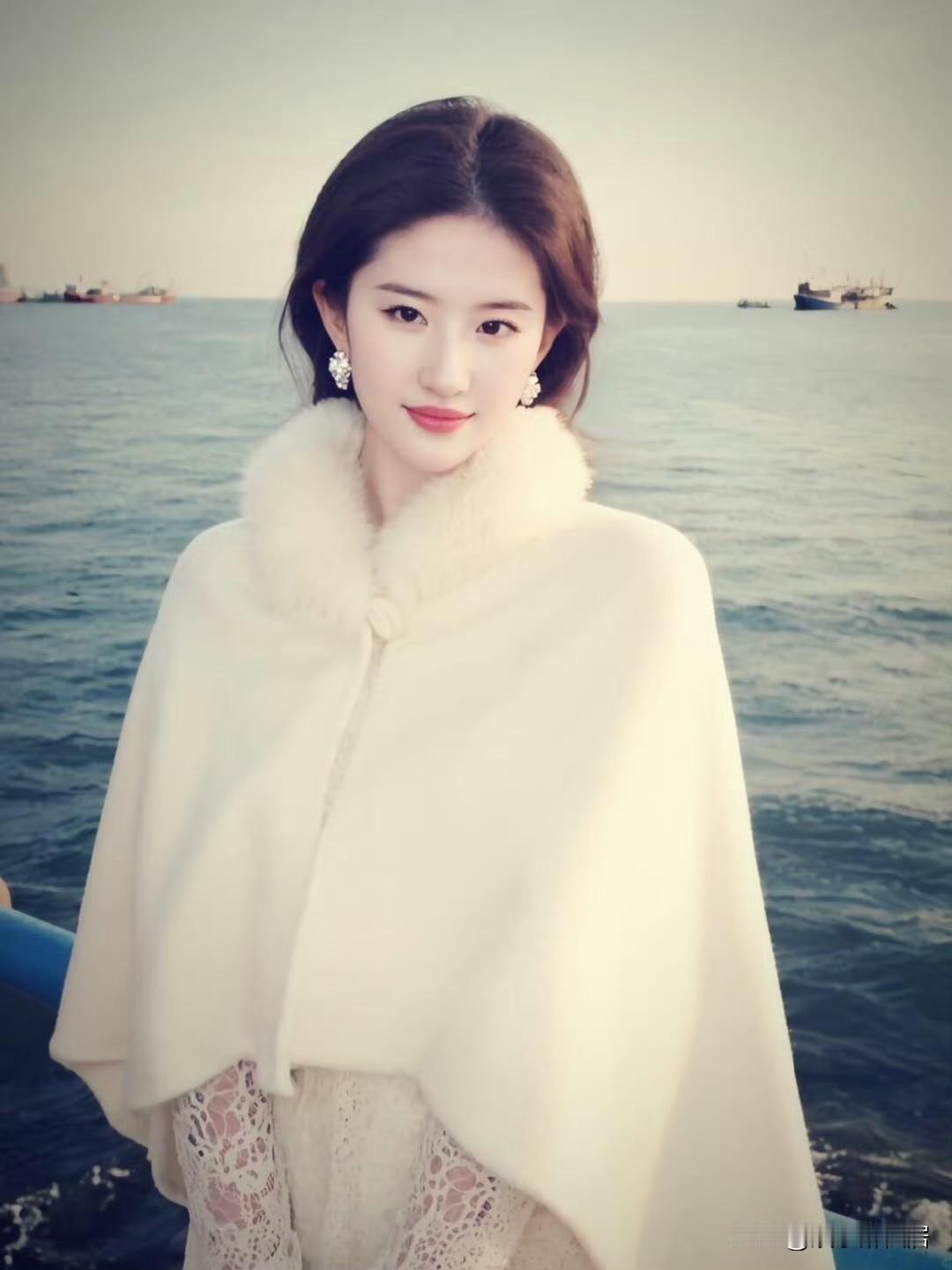 真是奇了怪了，刘亦菲这个清冷的气质真是独一份啊！照片中她身披白色斗篷式的外套，面