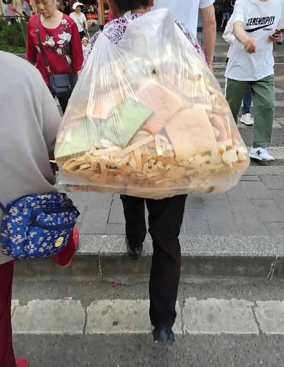 第一眼离远看到，还以为穿了一件蓬松花围裙。第二眼看到以为背了一袋碎布条。走近一看