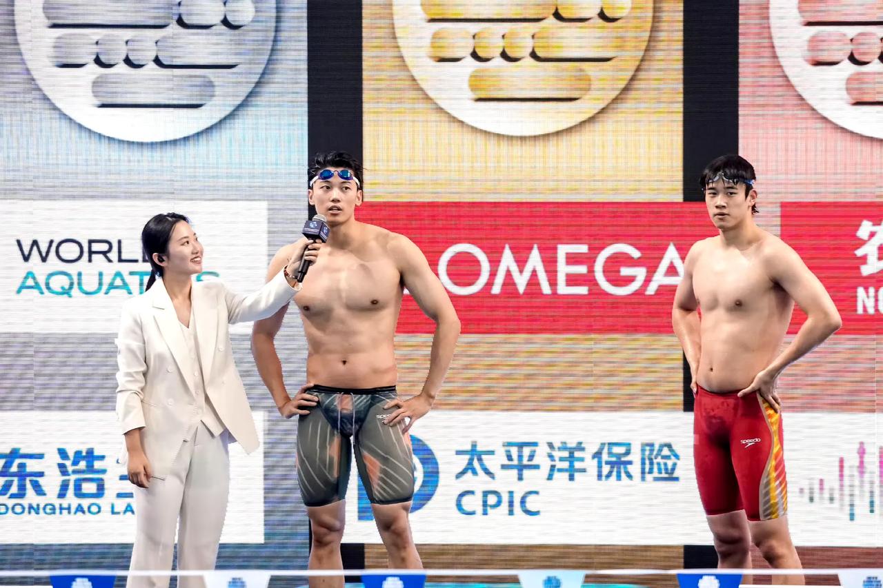 游泳世界体上海站比赛后采访的画面，看看这位美貌可爱的记者小姐姐努力举着话筒采访汪