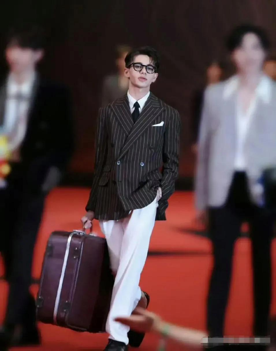 星光大赏出现比较奇葩的一幕，一位男星拎着箱子走红毯，到拍照的时候，直接站了上去，