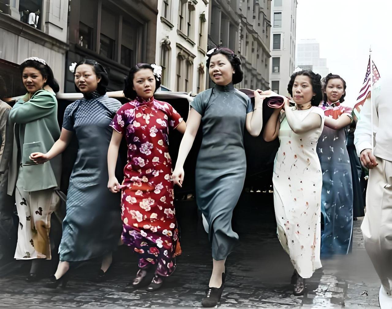 这是民国时期海外华人游行的场景！你瞅啊，好多穿旗袍的华人大姐、姑娘并肩走着，旗袍