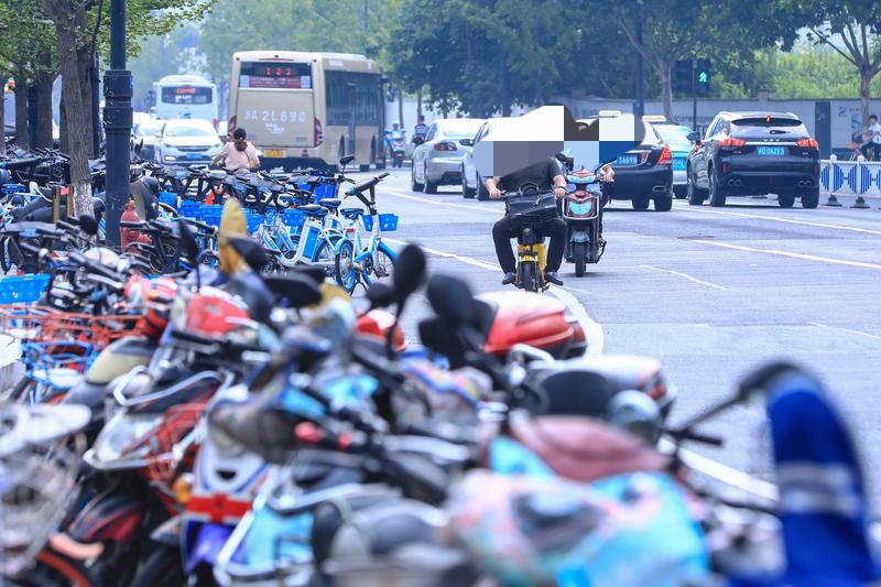 2月6日成都，路上停满了各种车辆影响通行 ，骑手只能冒险借用机动车道 ，一气之下