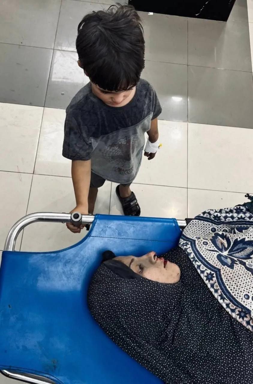 一名巴勒斯坦儿童告别他的母亲，他的母亲最近在以色列占领加沙的轰炸中丧生。[祈祷]