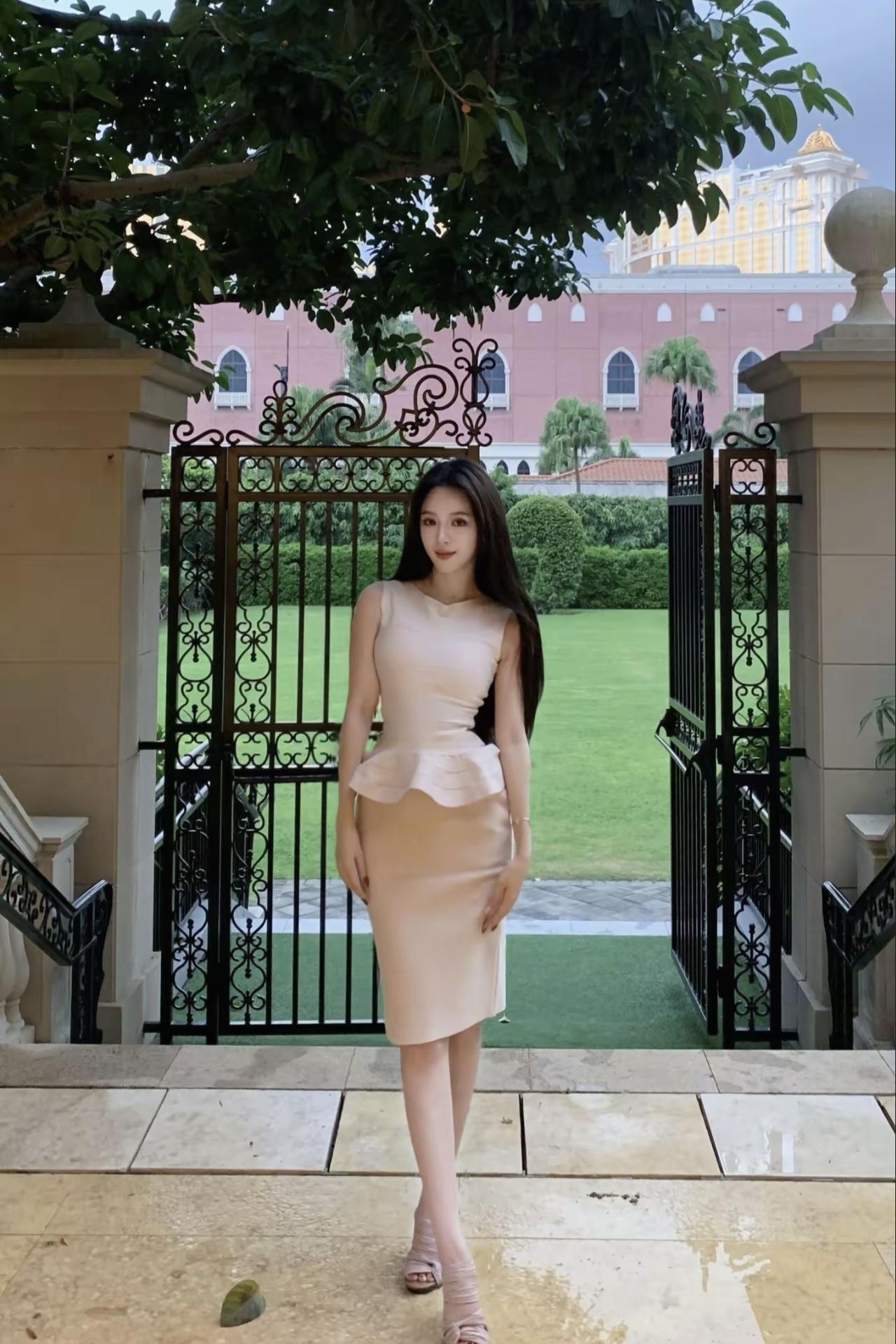 傍晚的风裹着草木香，连裙摆都沾了点松弛的温柔。身后的建筑像偷藏的童话书页，随便站