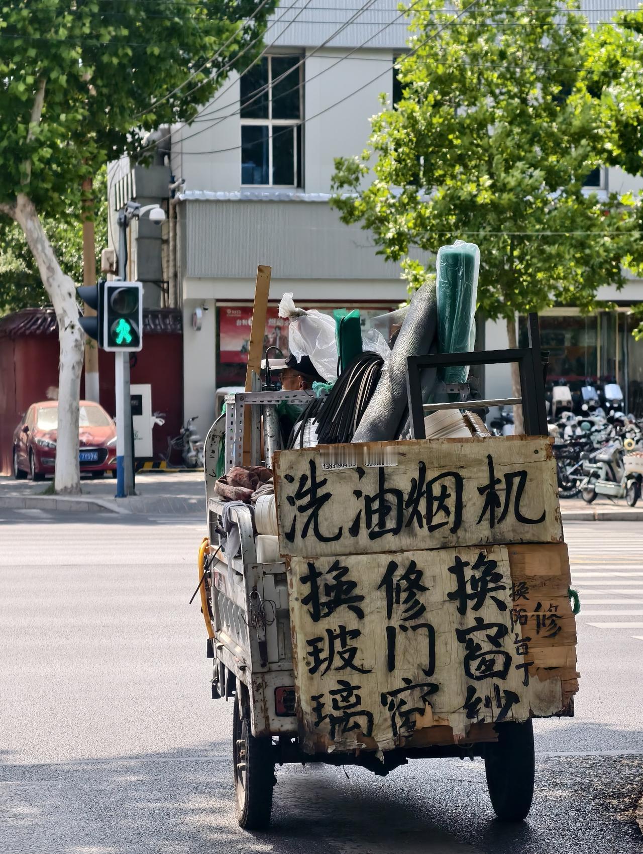 一块斑驳木板写满生计营生，三轮车驮着工具奔波街巷，寻常街头藏着最踏实滚烫的人间烟