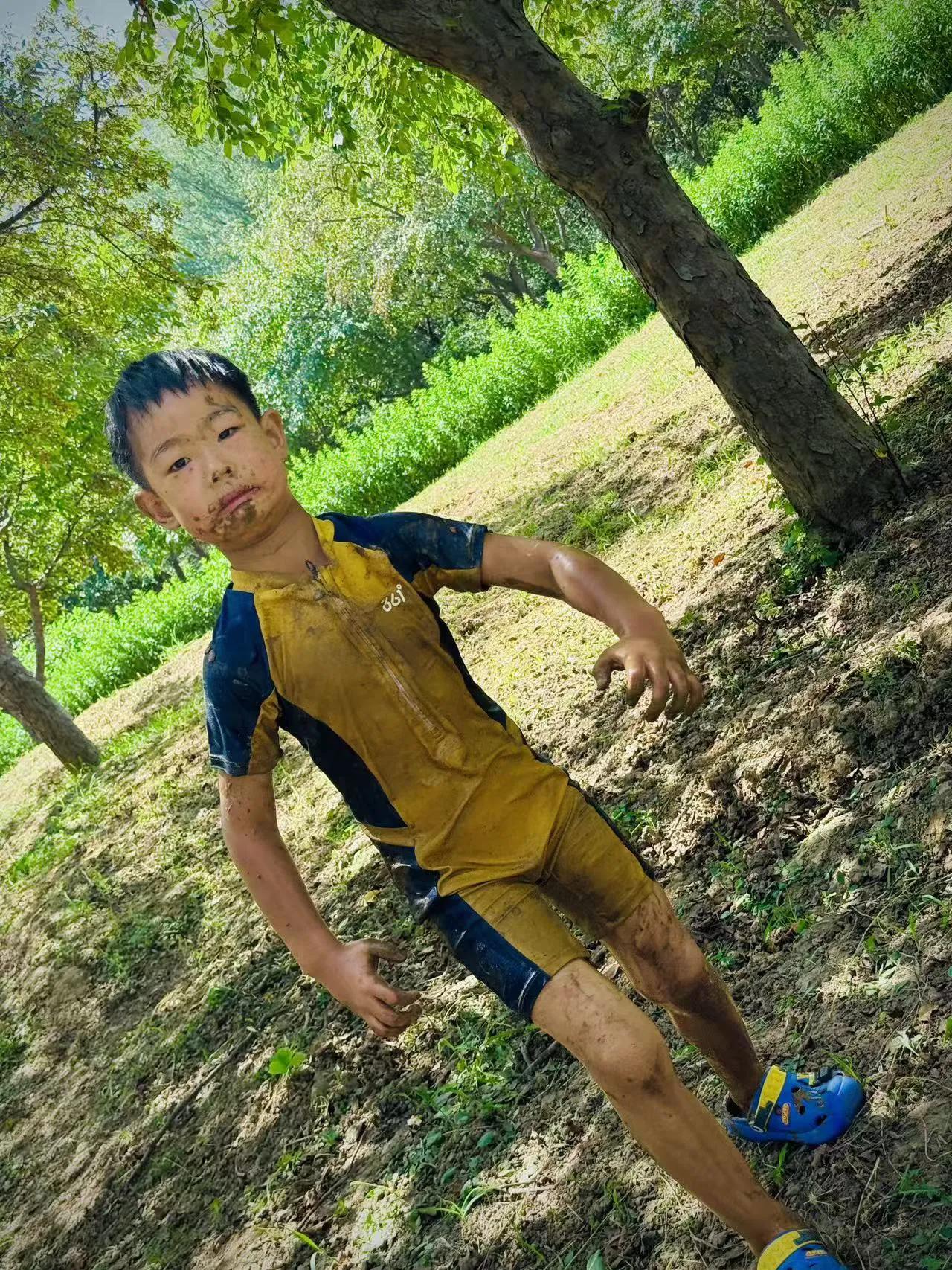 幼儿园后院的小泥水河是我们的乐园。雨后浅浅泥水缓缓流淌，老师给我们换上防水围裙。