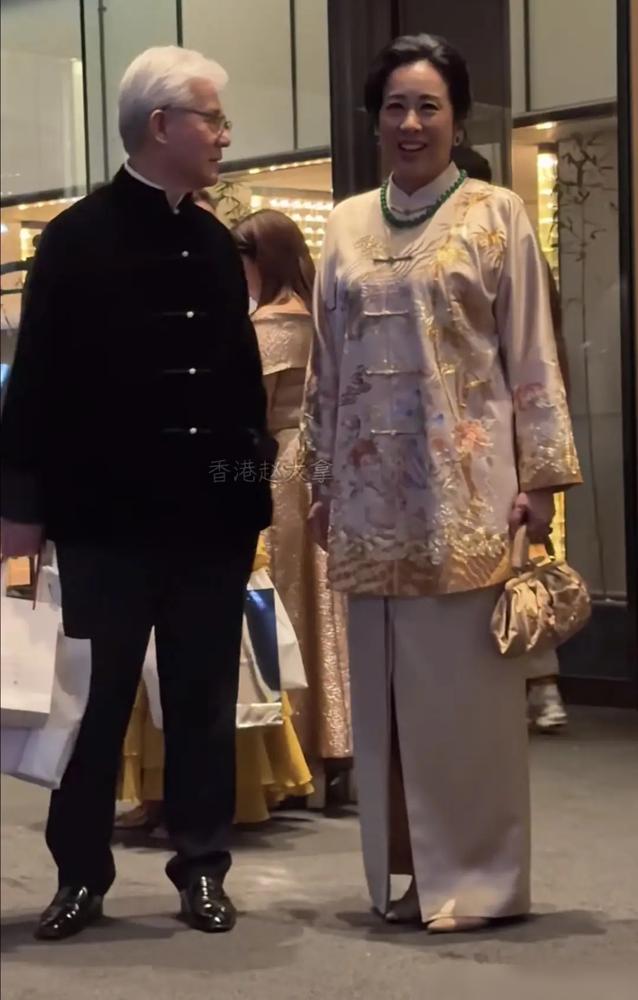 68岁朱玲玲一身凤褂戴帝王绿，现任老公罗康瑞在门口提包等车，前夫儿子霍启刚那边也